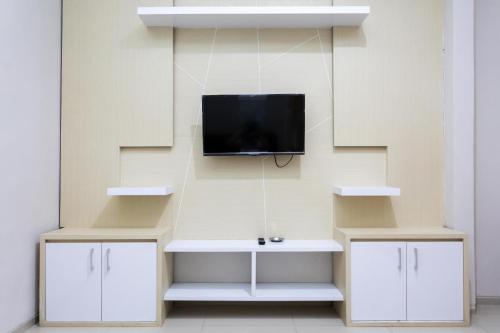a living room with a tv on a wall at Batuque Town Villa 2 in Batu