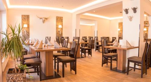 a dining room with wooden tables and chairs at Motel Am Bürgerpark in Werlte