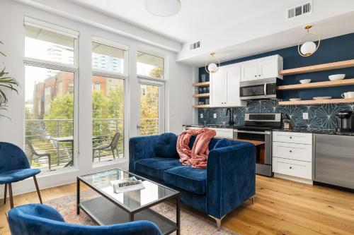 uma sala de estar com um sofá azul e uma mesa em Marvelous Midtown Manor In Piedmont Park em Atlanta