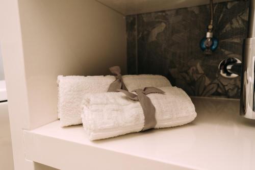 two towels sitting on a shelf in a bathroom at Affittacamere La Magnolia in Bacoli