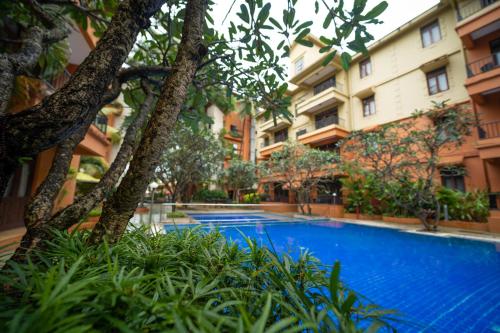 a swimming pool in front of some buildings at Neelam's The Grand Hotel Goa in Calangute