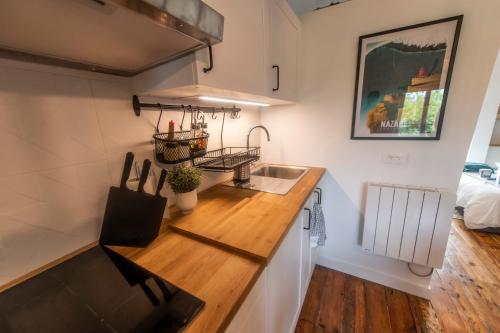 une cuisine avec un évier et un plan de travail en bois dans l'établissement Studio design - Proche plage, à Biarritz