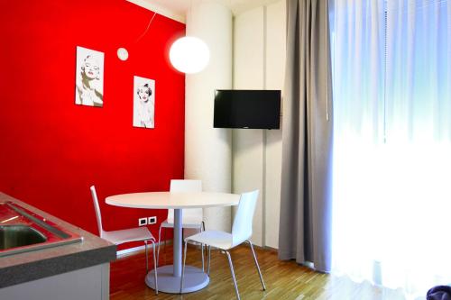 a kitchen with a table and a red wall at Hotel Mantova Residence in Mantova