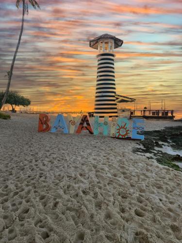 a lighthouse on the beach with a sign in the sand at Atmospheric apartment with a beautiful view of the swimming pool in Bayahibe