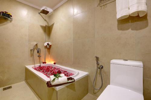 a bathroom with a bath tub with a toilet and a sink at Hotel Floral Park in Kottayam