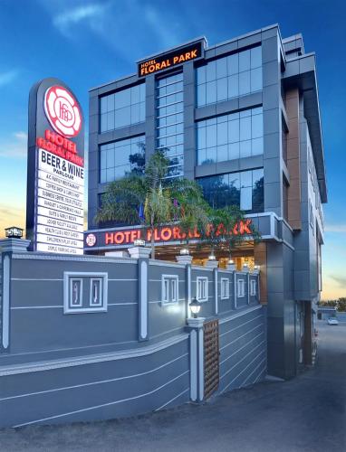 a hotel with a sign on the front of it at Hotel Floral Park in Kottayam