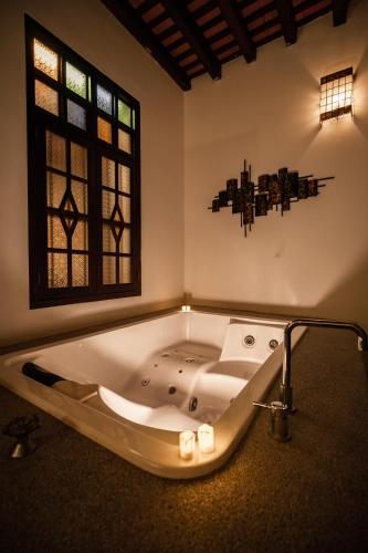 a large bath tub in a room with a window at Hotel Penaga in George Town
