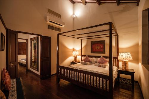 a bedroom with a canopy bed and a mirror at Hotel Penaga in George Town