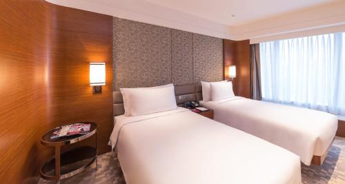 a hotel room with two beds and a table at Crowne Plaza Macau, an IHG Hotel in Macau