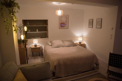 a bedroom with a bed and two lamps and a chair at Calme et cosy in Obernai