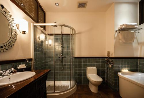 a bathroom with a shower and a toilet and a sink at Hotel Penaga in George Town