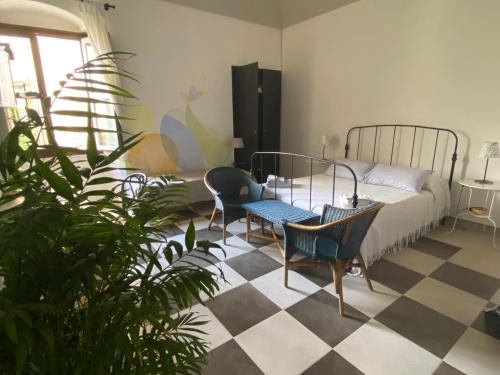 a bedroom with a bed and chairs and a checkered floor at A' naca in Ragusa