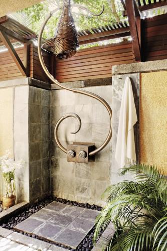 a bathroom with a shower with a towel at Shanti Maurice Resort & Spa in Bel Ombre