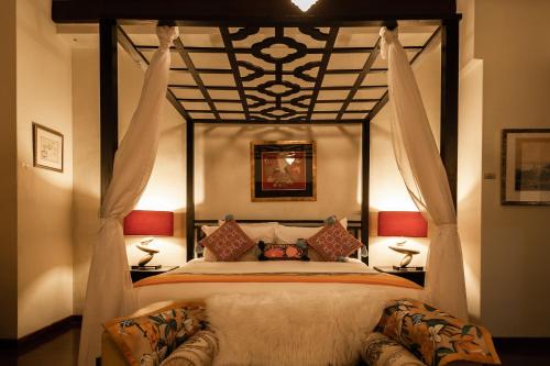 a bedroom with a canopy bed and two lamps at Hotel Penaga in George Town