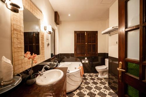 a bathroom with a sink and a tub and a toilet at Hotel Penaga in George Town