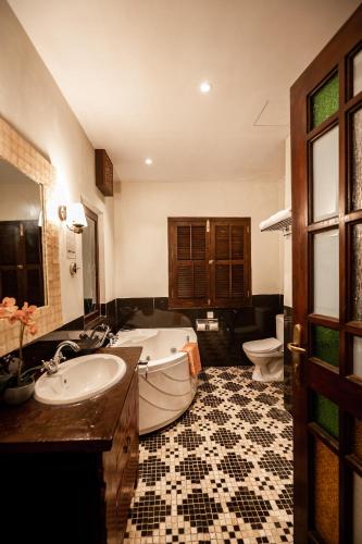 a bathroom with a sink and a tub and a toilet at Hotel Penaga in George Town