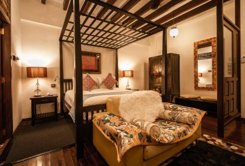 a bedroom with a four poster bed and a couch at Hotel Penaga in George Town
