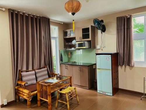 cocina con mesa y silla y cocina con nevera en Little Home Nha Trang Apartment, en Nha Trang