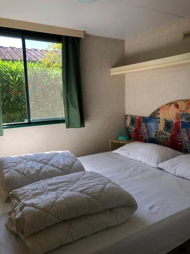 1 dormitorio con 2 camas y ventana en Toskana-Viareggio-Chalet-Zona-Rosa-5-mit-Klimaanlage-und-Wlan, en Viareggio