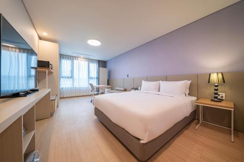 a hotel room with a large bed and a television at Best Western Asan Hotel in Asan