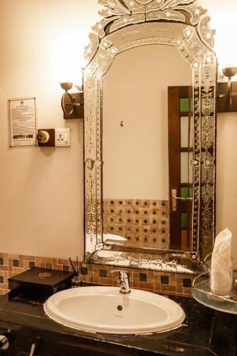 a bathroom with a sink and a large mirror at Hotel Penaga in George Town