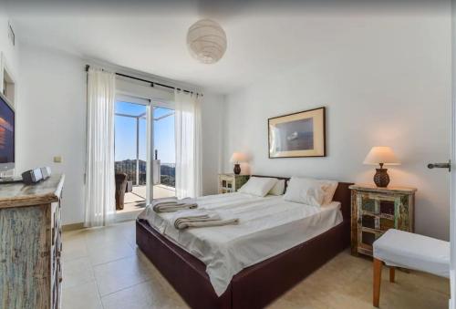 a bedroom with a large bed and a large window at Casa Afrodite in Almuñécar