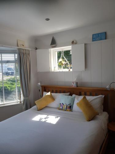 ein Schlafzimmer mit einem großen weißen Bett mit gelben Kissen in der Unterkunft The Slopes in Whitstable