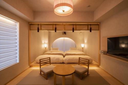 a bedroom with a bed and a table and chairs at moire HOTEL YOSHIWARA in Tokyo