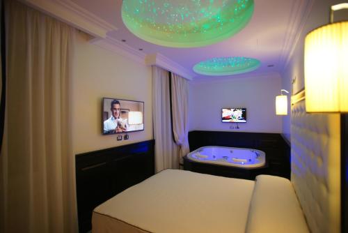 Pokój z łóżkiem, telewizorem i wanną w obiekcie Vaticano Royal Suite Guest House w Rzymie