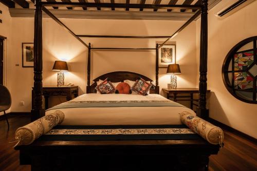 a bedroom with a four poster bed and two lamps at Hotel Penaga in George Town