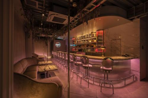 a bar with a row of chairs in a room at moire HOTEL YOSHIWARA in Tokyo