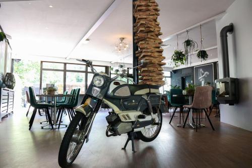 een motorfiets geparkeerd in een kamer met een eetkamer bij EuroParcs Maasduinen in Belfeld