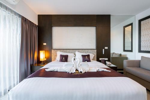 sypialnia z dużym łóżkiem i kanapą w obiekcie Lani Chiang Mai Hotel w mieście Chiang Mai
