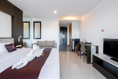 a bedroom with a large bed and a television at Lani Chiang Mai Hotel in Chiang Mai