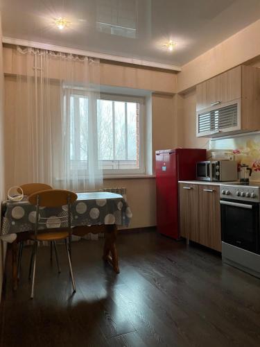 a kitchen with a table and a red refrigerator at Аэропорт in Irkutsk