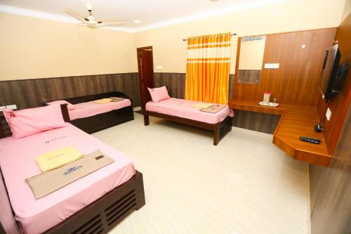 pokój hotelowy z 2 łóżkami i telewizorem w obiekcie RAMANA'S HOME STAY Apartment Hotel Kumbakonam w mieście Tańdźawur