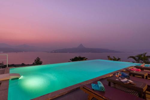 - une piscine avec vue sur l'eau dans l'établissement StayVista's Princess - A Villa with Infinity Pool & Breathtaking Views, à Lonavala