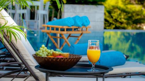 a glass of orange juice and a bowl of fruit on a table at Hotel Uvala in Dubrovnik
