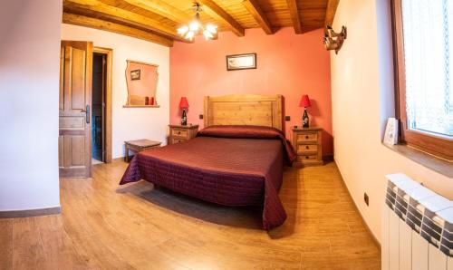 1 dormitorio con 1 cama y suelo de madera en casa rural La Gabina, en Muñogalindo