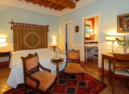 蒙特普齊亞諾的住宿－伊爾榮多精品酒店，一间卧室配有一张床、两把椅子和一张桌子