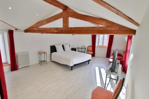 ein Schlafzimmer mit einem Bett und einem TV in einem Zimmer in der Unterkunft Le Relais Basque in Hagetmau
