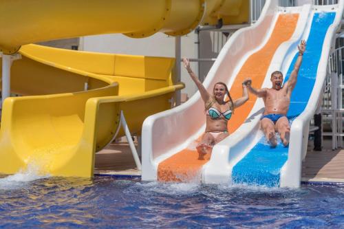 a man and a woman are sliding down a water slide at Sirius Deluxe Hotel in Alanya