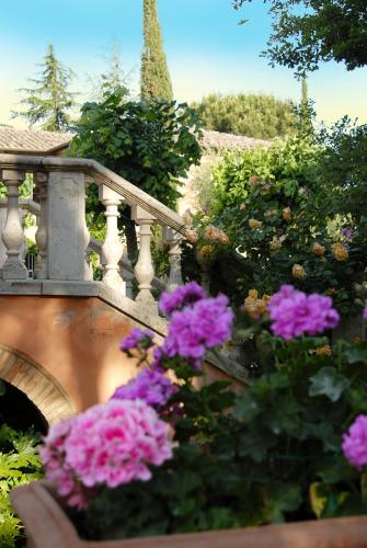 a bunch of pink flowers in front of a bridge at Il Rondò Boutique Hotel in Montepulciano