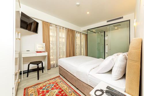 a bedroom with a bed and a desk and a television at Septimum Hotel in Istanbul