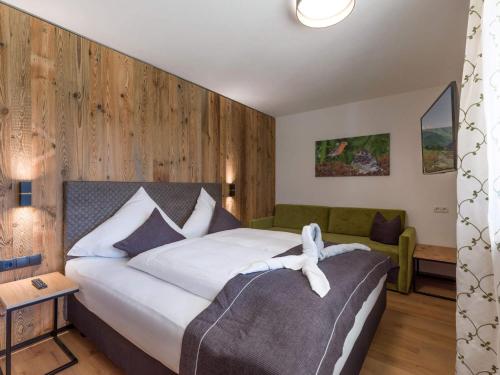 a bedroom with a large bed and a couch at Baderer Apart in Stumm