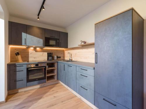 a kitchen with gray cabinets and stainless steel appliances at Baderer Apart in Stumm