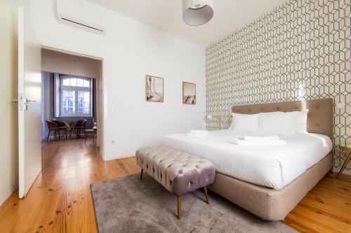 a bedroom with a large white bed and a table at Citybreak-apartments Sao Bento in Porto