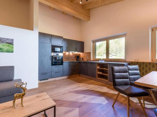 a large kitchen with a table and chairs in a room at Baderer Apart in Stumm