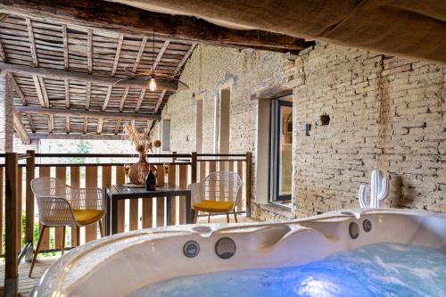 uma banheira num quarto com uma mesa e cadeiras em Le Cocon & SPA Privé - l'Oliveraie d'Eurocentre em Castelnau-dʼEstrétefonds