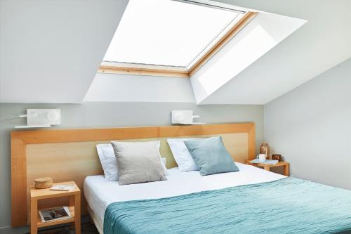 a bedroom with a large bed with a skylight at Résidence Valdys Thalasso & Spa - les Pins in Saint-Jean-de-Monts